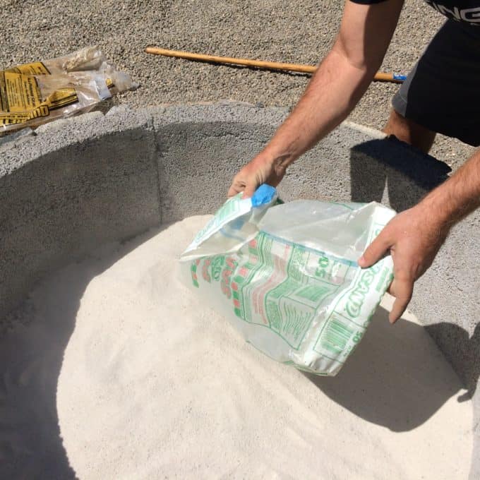 Use sand layered over gravel to line the base of a fire pit.