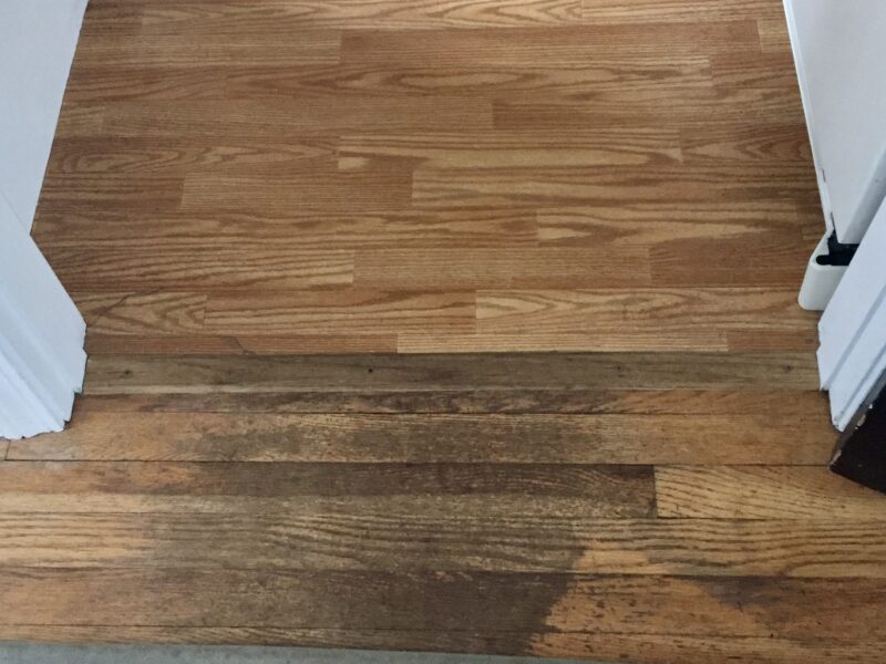 Vinyl and worn hardwood flooring before renovation